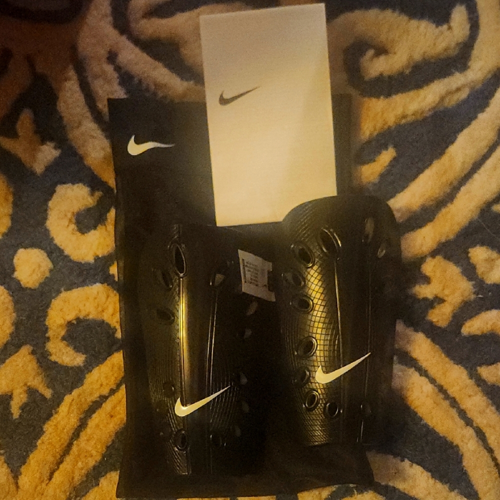 Nike Black small Shin Guards and size 3 adidas messi indoor soccer shoes.